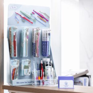 Assorted toothbrushes on a display stand in a dental clinic setting, emphasizing oral health.